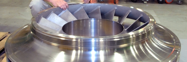 Ron Topper, supervisor of Rotor Division Machining and Assembly, looks over a large centrifugal compressor impeller. Many of the parts produced in the rotor department are as large as 80 inches in diameter
